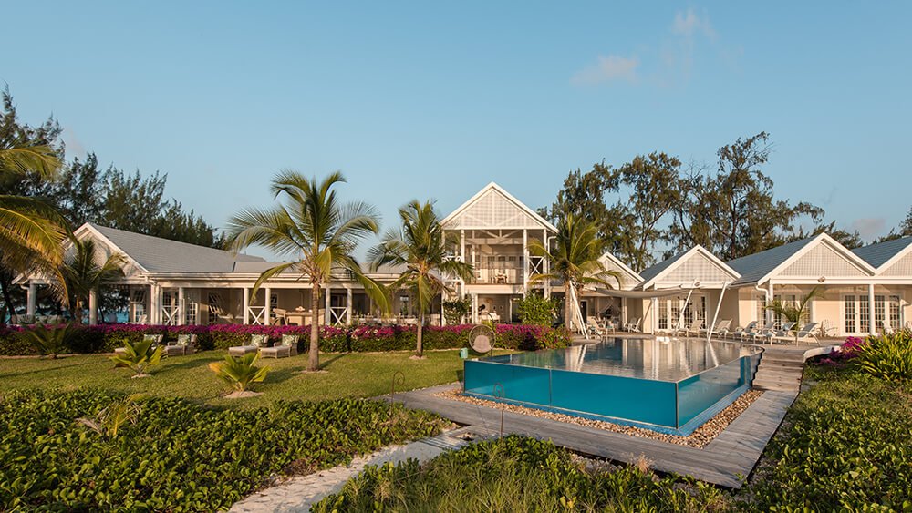 Beachfront villa and palm trees at Thanda Private Island
