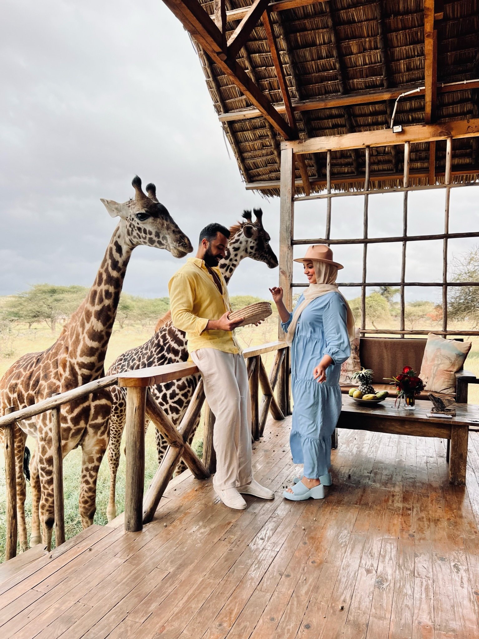 Couple watching giraffes from a wooden veranda at Serval Wildlife
