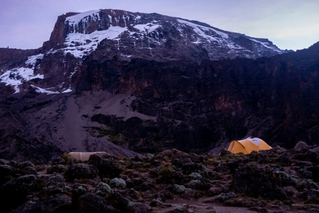 A tent in rocky mountain terrain — first-climb preparation with Tartaruga Safaris