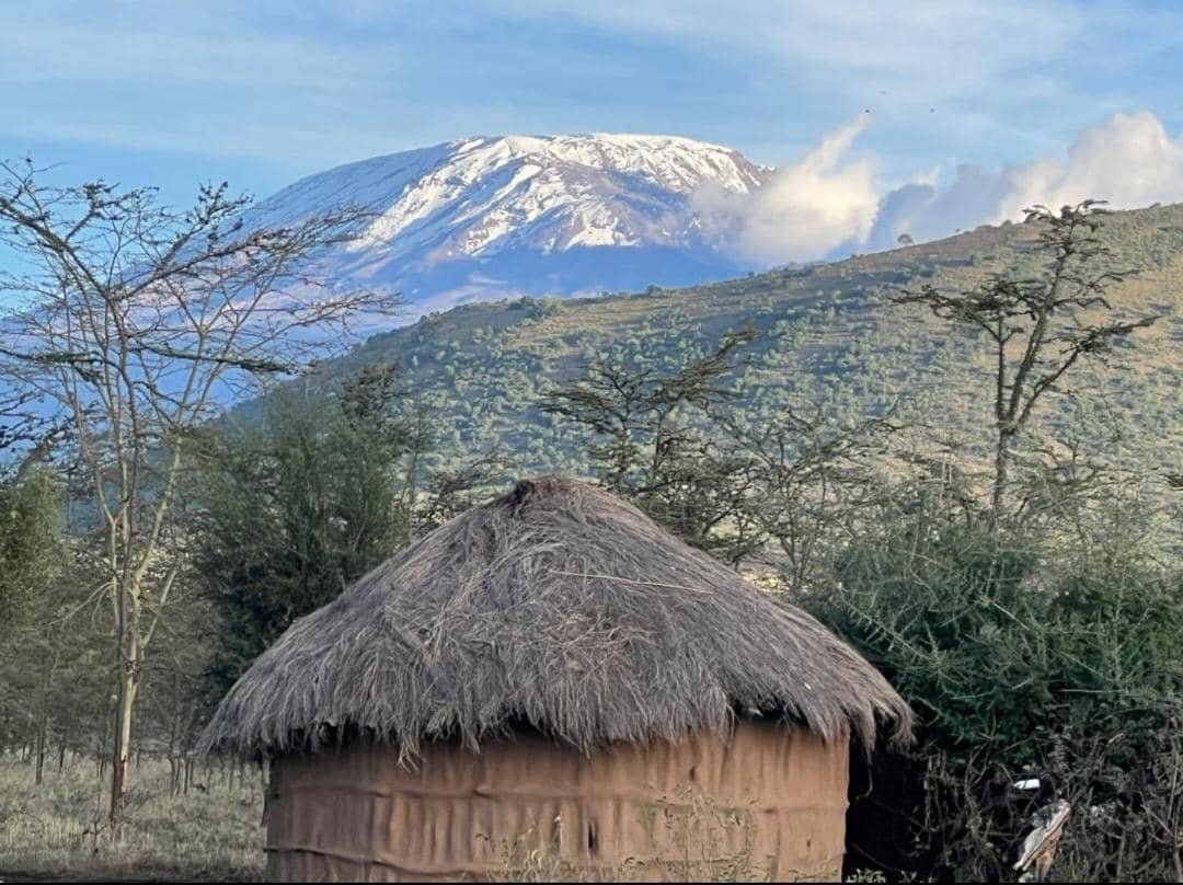 Kilimanjaro above green foothills — six-day Machame climb