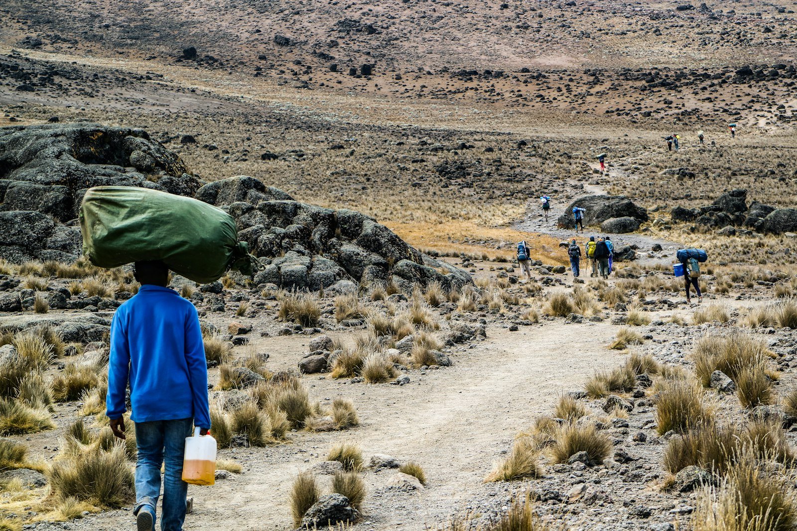 A porter carrying equipment on a mountain trek — packing advice from Tartaruga Safaris