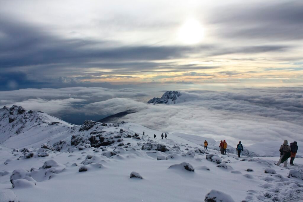 Climber above the clouds near Kilimanjaro summit at sunrise