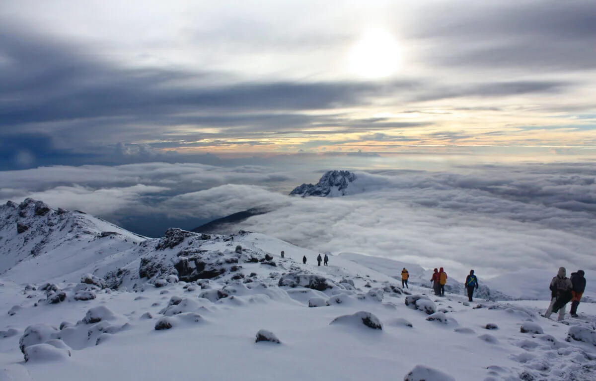 Climbers crossing a snowy mountain landscape