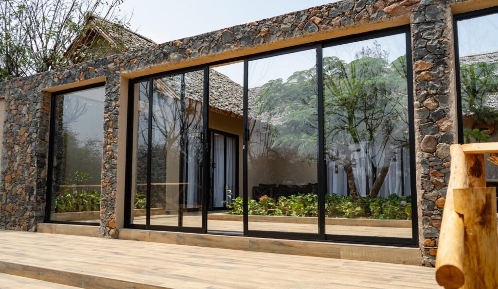 Stone-and-glass exterior of a Serval Wildlife family villa — Tartaruga Safaris