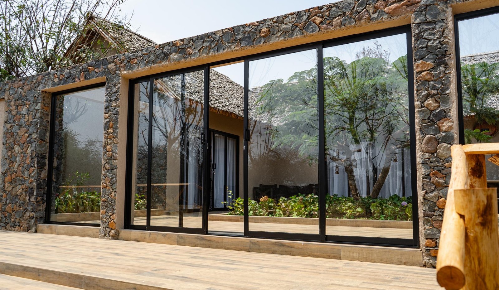 Stone-and-glass exterior of a Serval Wildlife family villa — Tartaruga Safaris