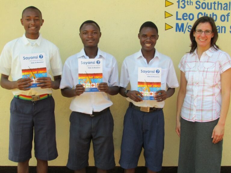 Students holding science textbooks during a 2013 Msandaka School visit — Tartaruga Safaris community information