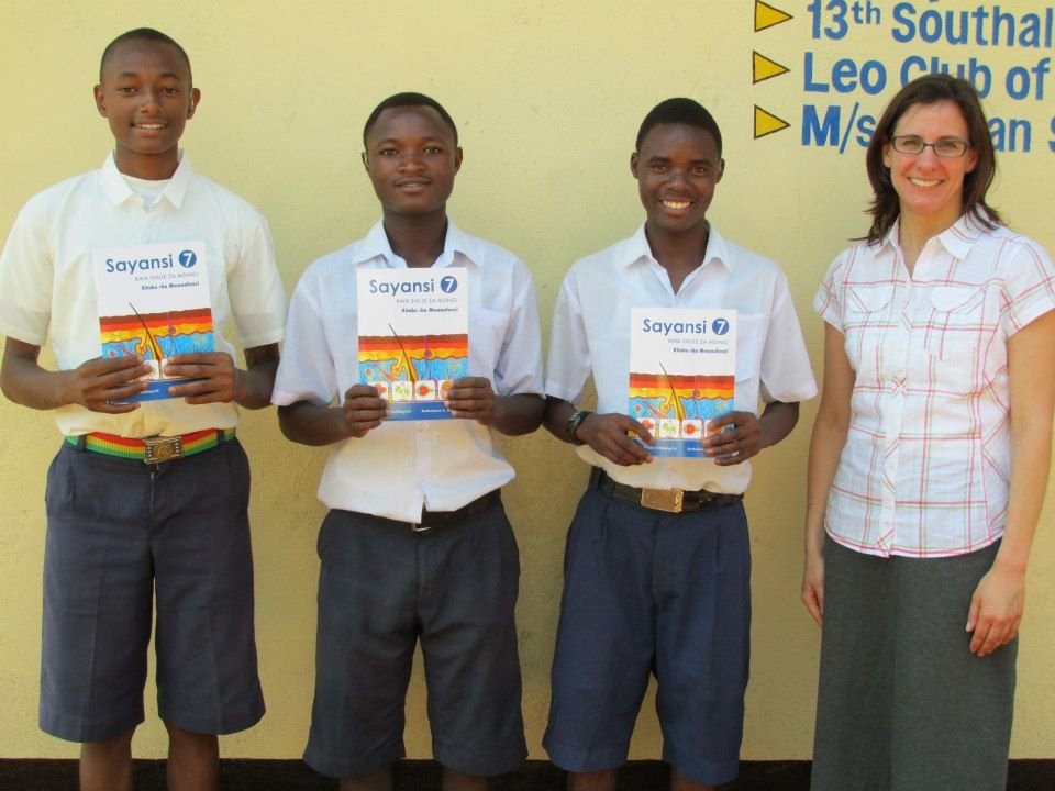 Students holding science textbooks during a 2013 Msandaka School visit — Tartaruga Safaris community information