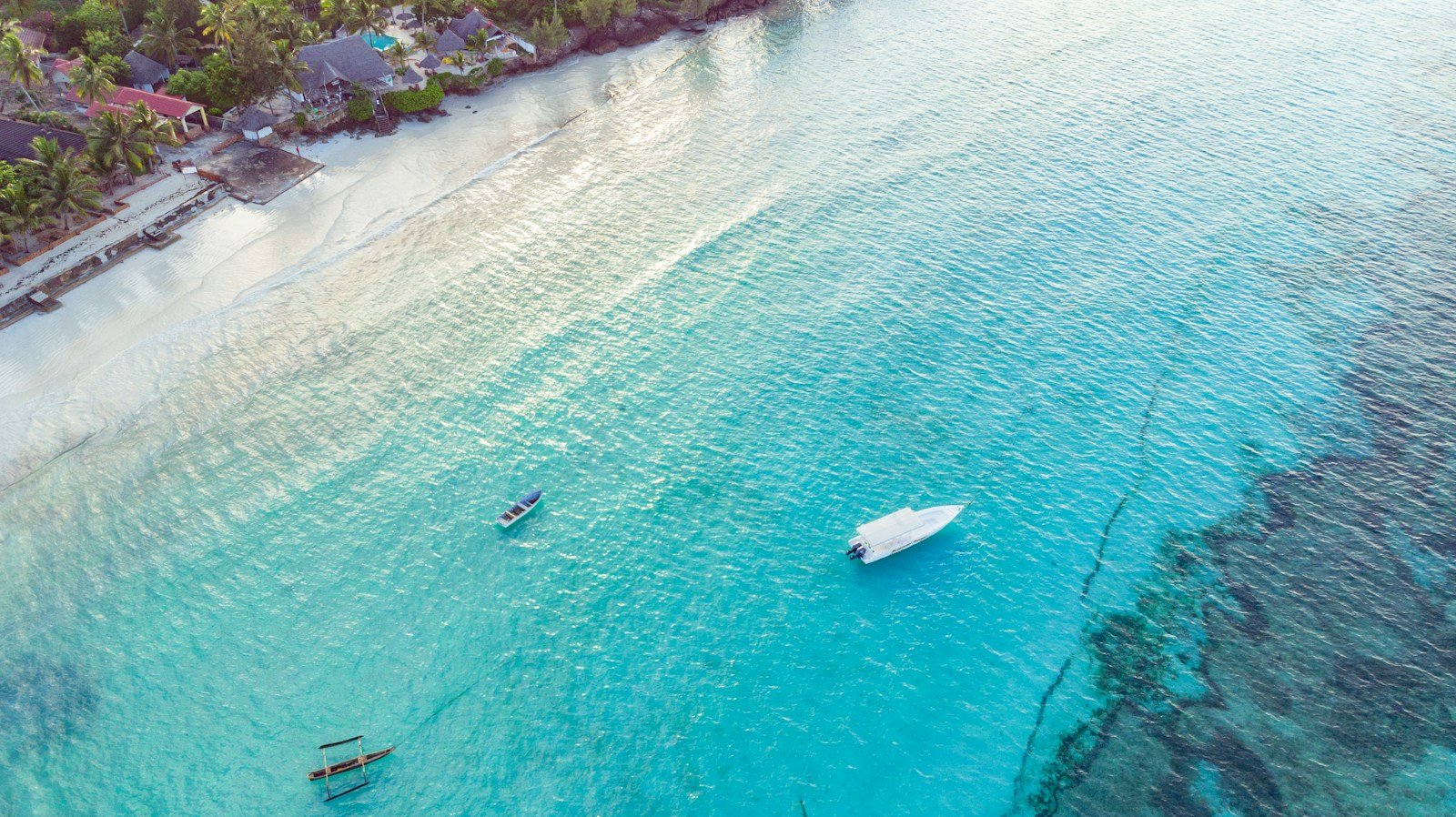 Boat on turquoise water beside the Zanzibar coast — Tartaruga Safaris