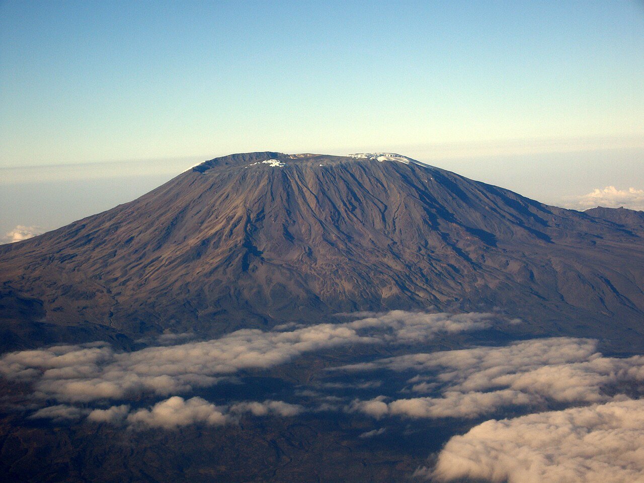 Vista aérea de um cone vulcânico acima das nuvens